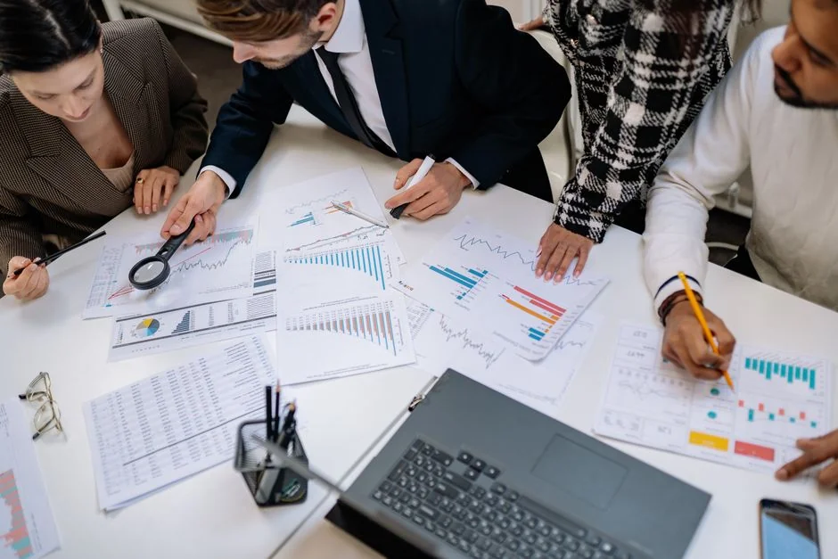 Two business professionals analyzing market trends on digital devices in an office setting.